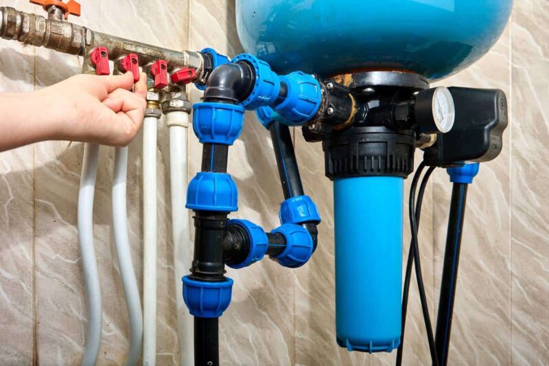 Main ajustant des vannes sur un système de filtration d'eau.